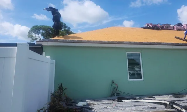 Roofing professional applying new roofing materials on a residential home in Palm Bay, showcasing restoration services by American Masters Roofing & Restoration.